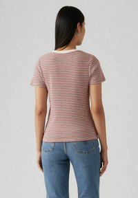 Camiseta ajustada de manga corta con rayas horizontales en burdeos y crema, hecha de tela suave, con un cuello redondo y una textura lisa.