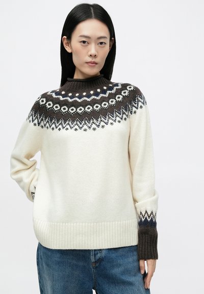 Strikket sweater i creme med et mønstret bærestykke i brun, hvid og blå. Har en høj hals og ribbede manchetter og kant. Blød tekstur.