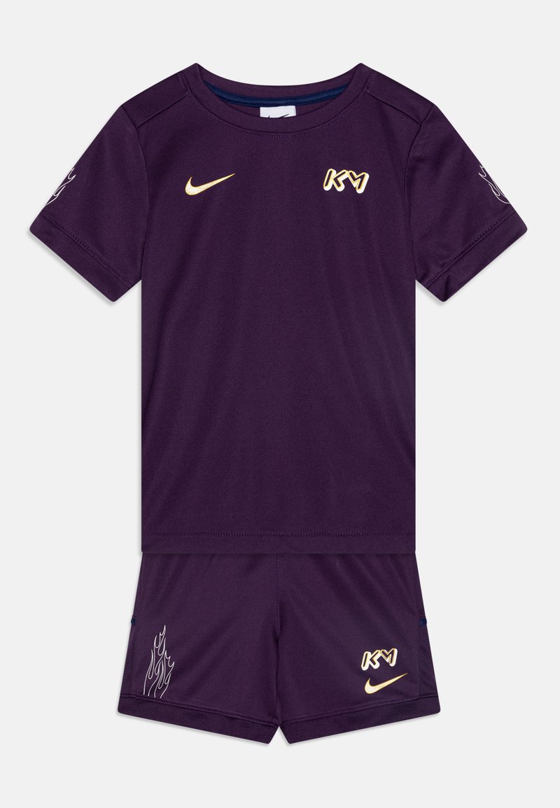 Lilla spordikomplekt lühikeste varrukatega. Omab Nike logo ja "KY" kuldse värviga, lühikeste pükste tulemustega. Sile tekstuur, sportlik istuvus.