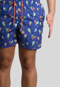Pantaloni da bagno blu con un vivace motivo di racchette e palline da tennis, dotati di una cintura elastica e dettagli arancioni sul cordoncino.
