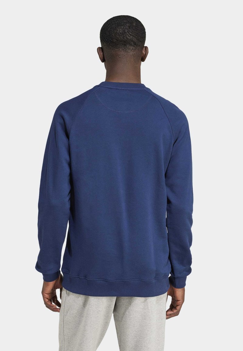 Granatowy sweatshirt z okrągłym dekoltem, długimi rękawami raglanowymi i ściągaczami. Wykonany z fakturowanej tkaniny, o gładkim designie bez widocznych akcentów.