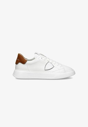 Sneaker bianco, tomaia in pelle con accento beige sul tallone, design perforato sul lato, punta rotonda e suola in gomma bianca.