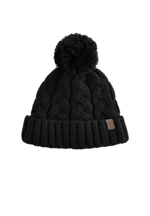 Bonnet d'hiver noir tricoté avec des motifs torsadés, un grand pompon sur le dessus, et un bord-côte replié avec une petite étiquette de logo marron.