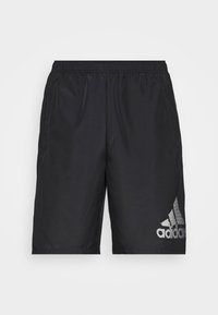 Shorts de sport noirs avec une ceinture élastique et le logo Adidas sur la partie inférieure de la jambe droite, présentés sur un fond blanc uni.