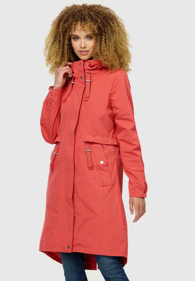 Abrigo impermeable color coral con capucha, herrajes plateados, cintura con cordón y dos bolsillos frontales. Textura suave con un diseño de longitud media.