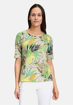 Korte mouwen, beige t-shirt met kleurrijke bladerenprints in groen, geel en zwart. Zachte stof, ronde halslijn, losse pasvorm.