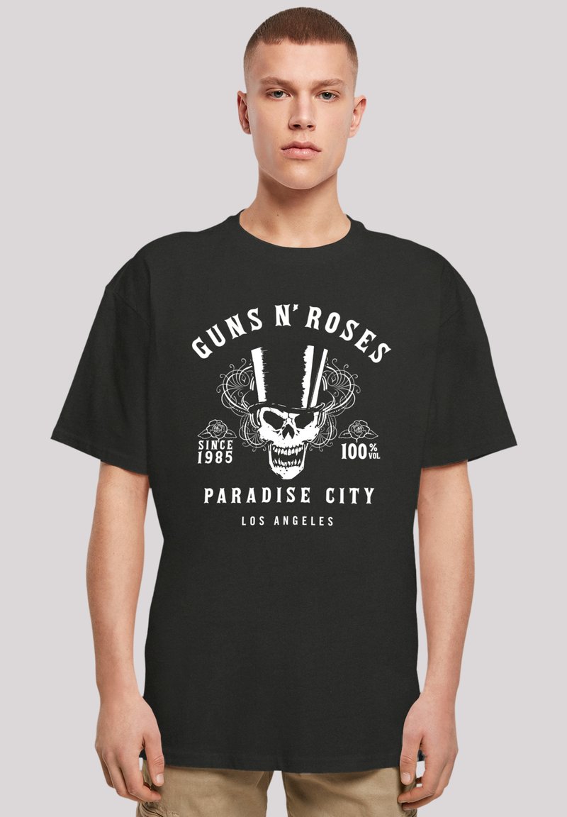 Black cotton t-shirt featuring a central white graphic of a skull with a top hat and text: "GUNS N' ROSES," "PARADISE CITY," and "SINCE 1985."