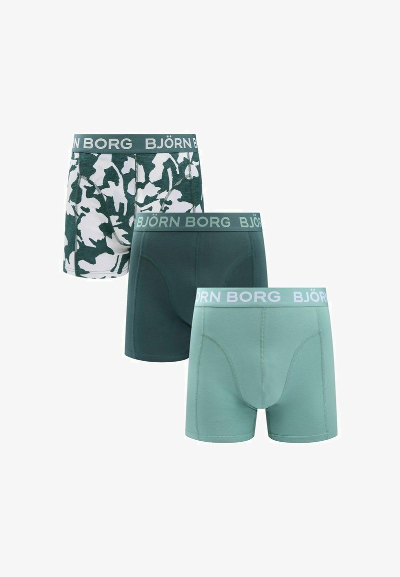 Trois boxers pour hommes en nuances de vert : vert foncé uni, vert clair et camouflage vert-blanc, tous avec une ceinture de marque Björn Borg.