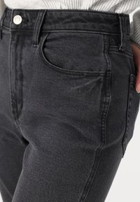 Jeans in denim nero con vita alta, tasche anteriori e una forma aderente. Il tessuto presenta una leggera texture con una finitura liscia.