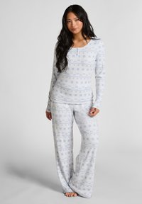 Komplet piżamowy z długim rękawem w jasnoniebieskim kolorze, zdobiony kwiatowymi wzorami. Miękki materiał, luźny krój i szerokie spodnie z subtelną teksturą.