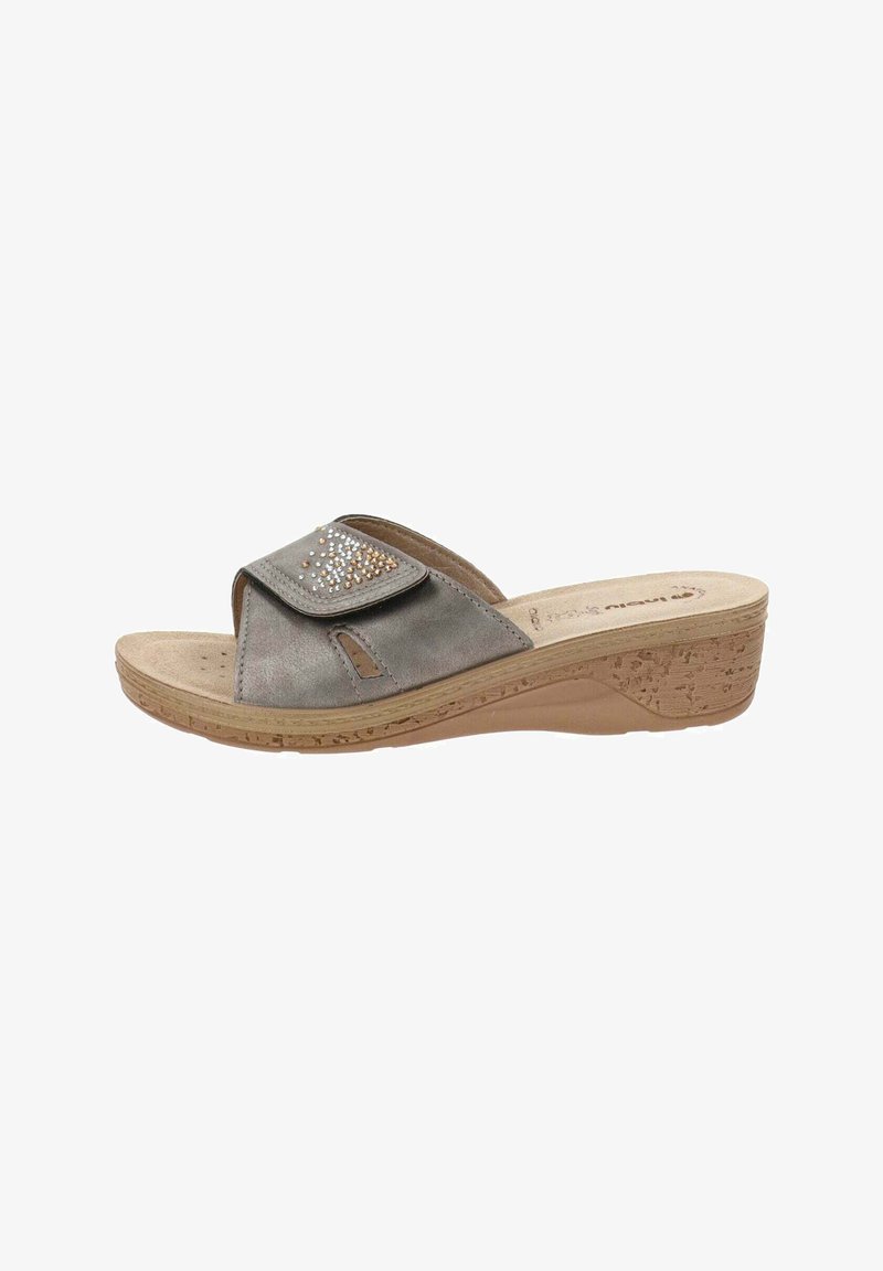Sandal en daim gris avec un bout ouvert, une sangle réglable et des strass décoratifs en argent et bronze. Semelle en liège pour un soutien optimal.