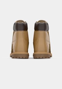 Scarpe da trekking in pelle tan con finitura lucida, colletto imbottito marrone e suole in gomma robuste, con cuciture visibili e dettagli sul tallone.