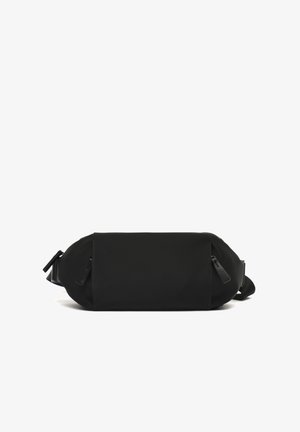 Sac à épaule noir et rectangulaire en tissu texturé, doté de deux poches zippées et d'une bandoulière réglable pour un transport polyvalent.