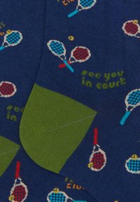 Calzini blu navy con tallone e punta verdi. Presentano racchette da tennis e palline dai colori vivaci, con la scritta "ci vediamo al campo" intrecciata in verde.