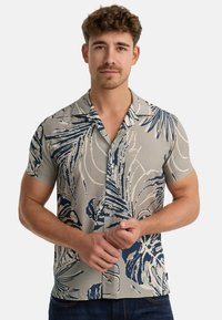 Camisa de manga corta en tela gris claro con un gran patrón de hojas azules. Diseño con botones y cuello, y un corte holgado.