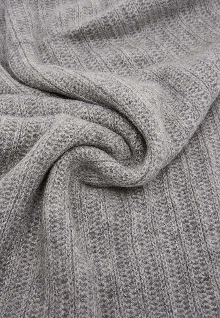 Tejido de punto suave en gris claro con textura de canalé vertical, doblado y retorcido para mostrar grosor y detalle.