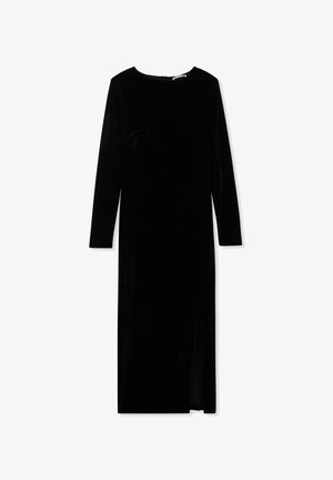 Abito lungo in velluto nero con maniche lunghe, scollatura rotonda e spacco laterale. Texture liscia, silhouette aderente e chiusura con zip sul retro.