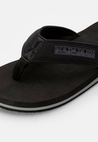 Infradito nera con suola in gomma testurizzata, cinturino in tessuto a forma di laccetto e logo impresso a rilievo sul cinturino. Design semplice e funzionale.