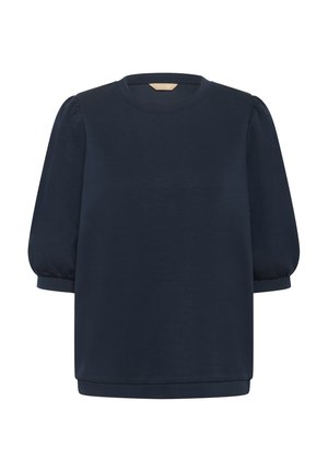 Tumši zils īsām piedurknēm krekls ar apaļu izgriezumu un uzpūstām piedurknēm. Izgatavots no mīksta materiāla; brīvs piegriezums ar taisnu apakšu.