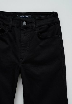 Jeans negros con una textura suave, que cuentan con un cierre de cremallera, cinco bolsillos y detalles de costura sutiles. La etiqueta dice "Salsa Jeans Destiny."