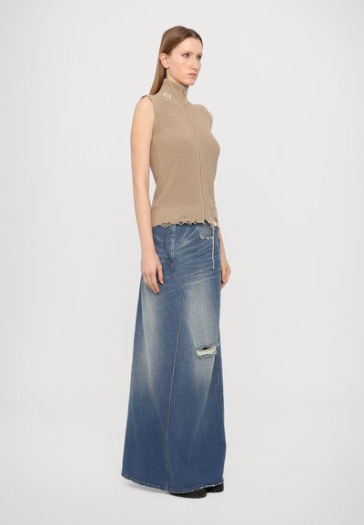 Beige sleeveless top with high collar, ribbed texture, and zipper. Paired with a long, light blue denim skirt featuring distressed details.