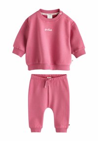 Rosa bomullssweatshirt med korta ärmar och broderad detalj, tillsammans med matchande byxor med elastisk midja och knytframsida.