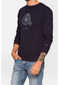 Sweat-shirt marine en mélange de coton avec un col rond. Présente un graphisme de bicyclette en gris clair et des poignets et un ourlet côtelés.