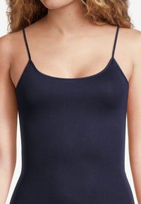 Navy blue camisole top with thin adjustable straps, seamless design, smooth texture, and a fitted silhouette.