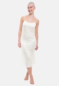 Abito da sera in satin bianco con spalline sottili, caratterizzato da un corpetto aderente e una gonna che scorre delicatamente, design minimalista e texture liscia.
