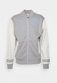 Gray zip-up jacket with white sleeves. Features a Nike logo in light blue, side pockets, and ribbed cuffs with stripes. Made of soft fabric.