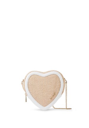 Beige vävd crossbodyväska i hjärtform med vit kant och tunn guldkedjestrap på vit bakgrund.