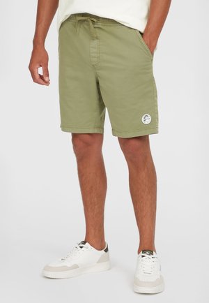 Olive green shorts with an elastic waistband and drawstring, feature side pockets and a round logo patch on the left leg.