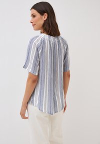 Gestreepte blouse met korte mouwen in blauw en wit, met een geplooide detail bij de halslijn en een iets langere achterzoom. Zachte stoftextuur.
