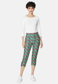 Kleurige capri's met een groene basis en een bloemenpatroon in roze, geel en blauw. Gemaakt van rekbare stof met een strakke pasvorm.