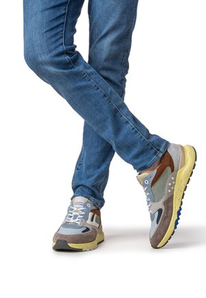 Baskets légères présentant un mélange de matériaux gris, bleu, marron et jaune, avec des accents en maille et une semelle texturée.