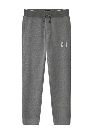 Pantalons de survêtement gris en tissu doux, avec une taille élastique à cordon et des poches latérales. "H" brodé sur la cuisse gauche. Design avec jambes fuselées.