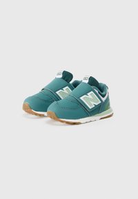 Teal New Balance 574 dječje cipele s čičak trakama, bijelim akcentima i potplatima od gume. Imaju podstavljeni ovratnik i mrežasti jezik.
