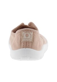 Scarpa slip-on in tessuto rosa con colletto imbottito, suola in gomma bianca e etichetta con marchio sul retro. Texture morbida e design casual.