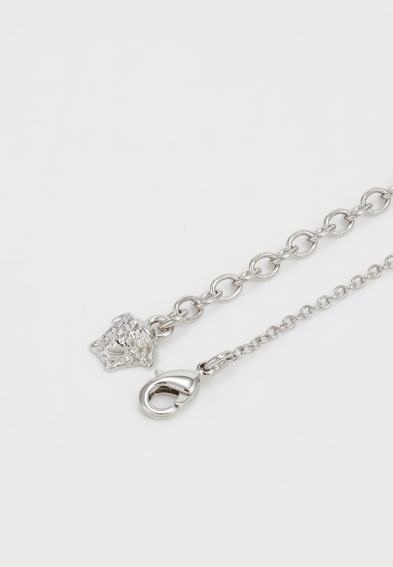 Silberkette mit einem Löwenkopfdesign an einem Ende und einem Karabinerverschluss am anderen Ende; glatte Textur mit miteinander verbundenen ovalen Formen.