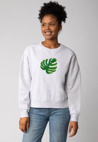 Grau sweatshirt mit lockerer Passform, auf der Vorderseite mit einem grünen Monstera-Blatt-Graphic. Baumwollmaterial mit gerippten Bündchen und Saum.