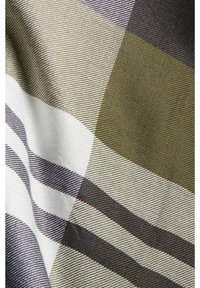 Gros plan sur un tissu à motif à carreaux comportant des rayures horizontales et verticales vert olive, blanc et gris foncé.