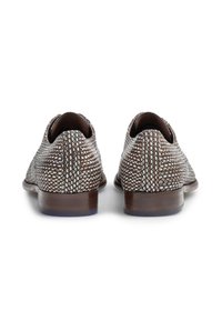 Scarpe marroni e bianche con una superficie strutturata che ricorda la pelle di serpente, punta arrotondata e tacco di legno basso, viste da dietro.