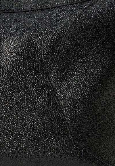 Fekete texturált bőr kézitáska dombornyomott felülettel, ferde varrásokkal és finom szemcsézettséggel, modern, strukturált megjelenést kölcsönözve.