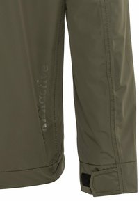 Veste légère vert olive avec une texture lisse, présentant un logo imprimé sur le côté et un poignet réglable par Velcro.