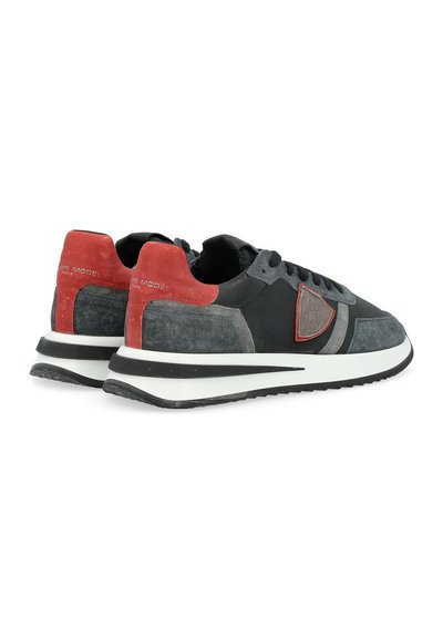Sneaker in suede e pelle nera e grigia con dettagli rossi, dotati di una intersuola bianca, lacci rotondi e suola testurizzata.