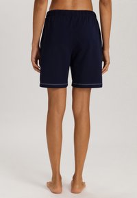 Pantaloni sportivi blu navy con una vita elastica, caratterizzati da una texture liscia e un leggero bordo a contrasto all'orlo.