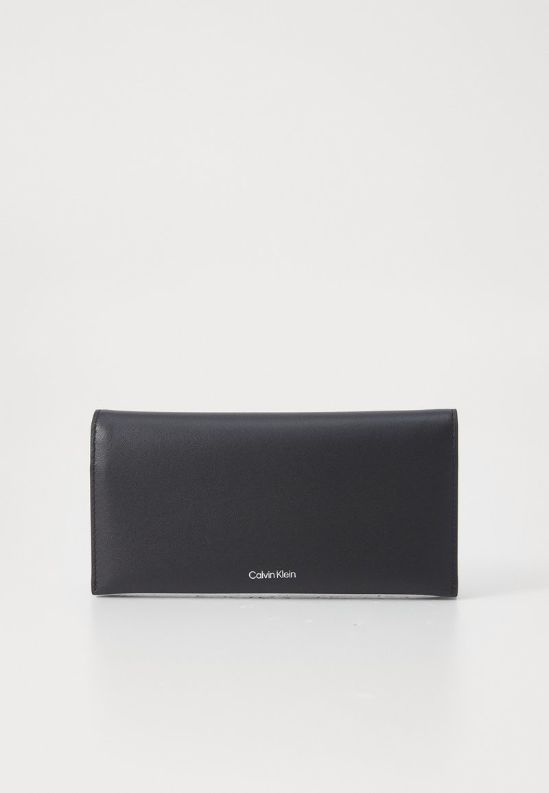 Čierna kožená peňaženka s elegantným, obdĺžnikovým dizajnom. Vyznačuje sa hladkým povrchom a diskrétnym logom Calvin Klein v dolnej časti.