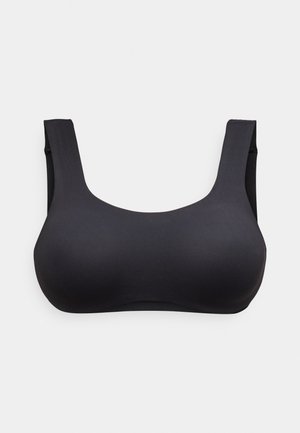 Črni brezšivni brezžični nedrček z širokimi ramenskimi naramnicami in okroglim izrezom, položen na svetlo ozadje.