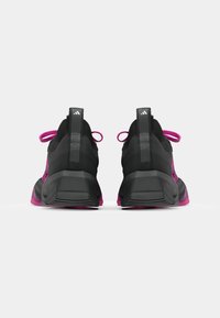 Sorte og rosa treningssko med teksturert stoff, polstret såle, fremtredende hæl og kontrastfargede snøringer. Har logo på hæltab.