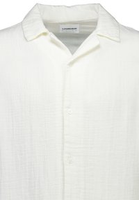 Camisa blanca de algodón texturizada con botones en la parte delantera y cuello abierto, etiqueta "Lindbergh White" en el interior del cuello.